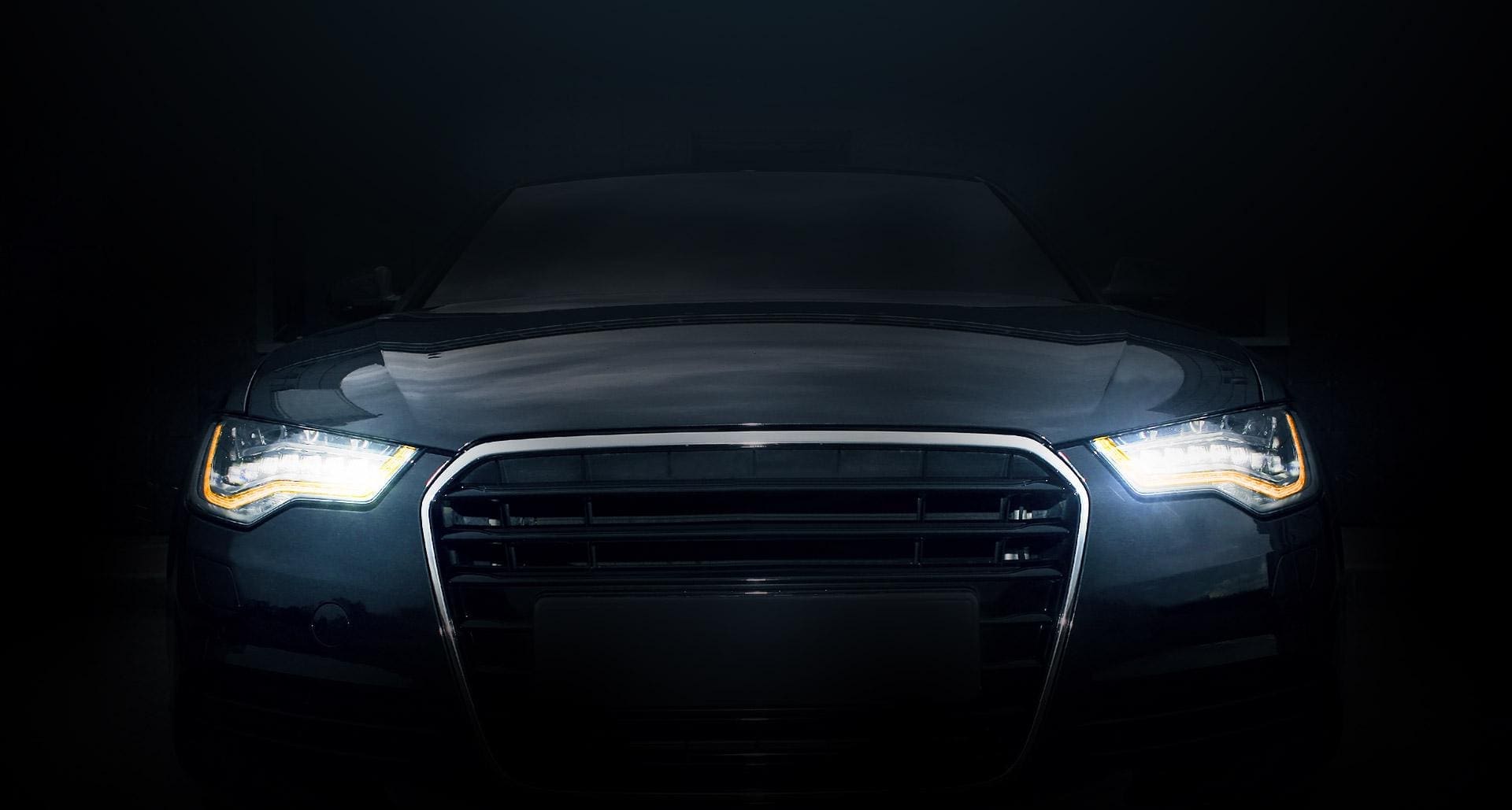 Samochód stojący w ciemności z włączonymi światłami
